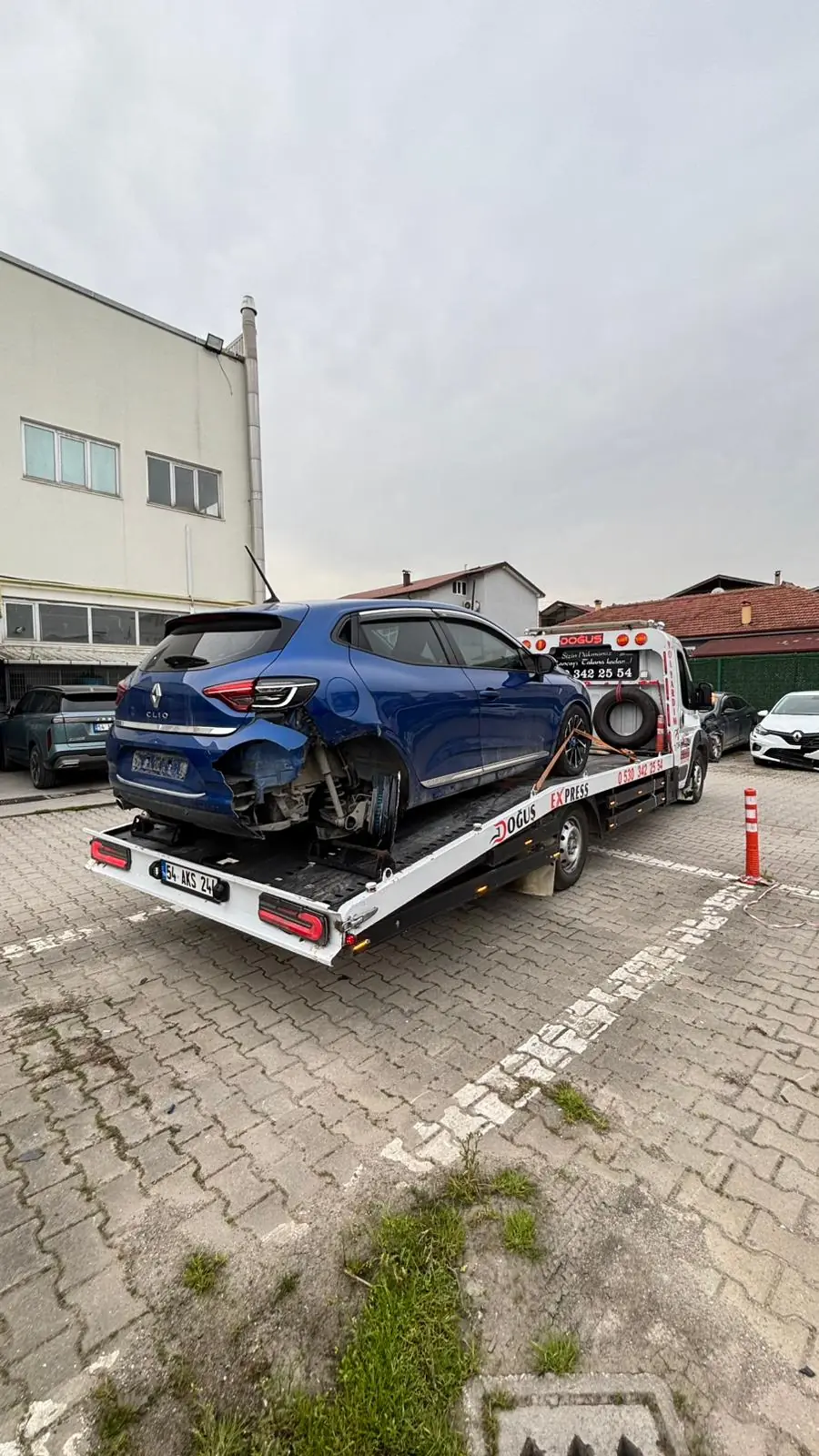Hasarlı mavi otomobilin servis alanına çekiciyle teslimi
