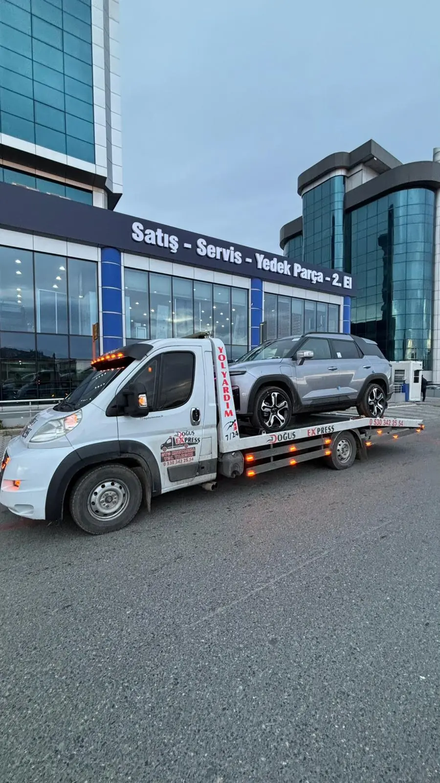 Beyaz SUV'nin oto galeri önüne çekiciyle teslim edilmesi