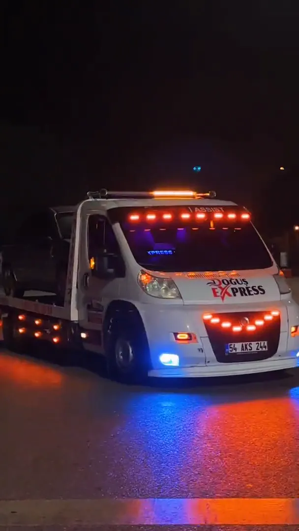 Doğuş Express çekicisi gece, tepe lambaları yanık hâlde ıslak yolda